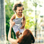 woman lifting child